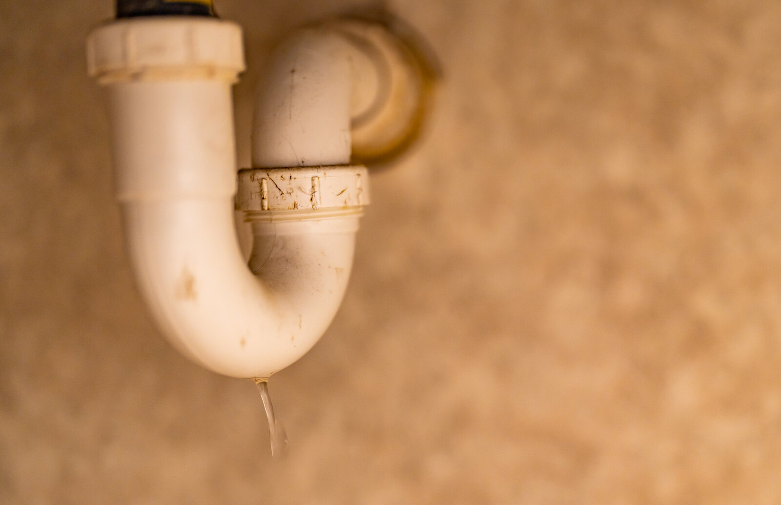 Water dripping from the trap under a kitchen sink
